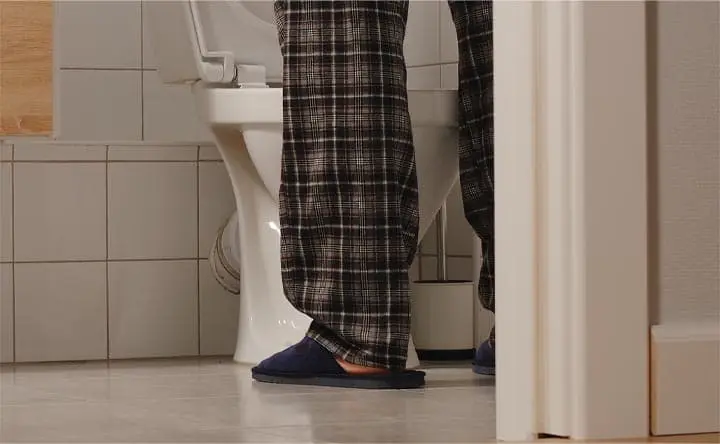 man standing in a bathroom in pajamas