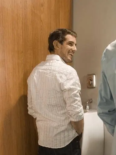 man in bathroom at urinal